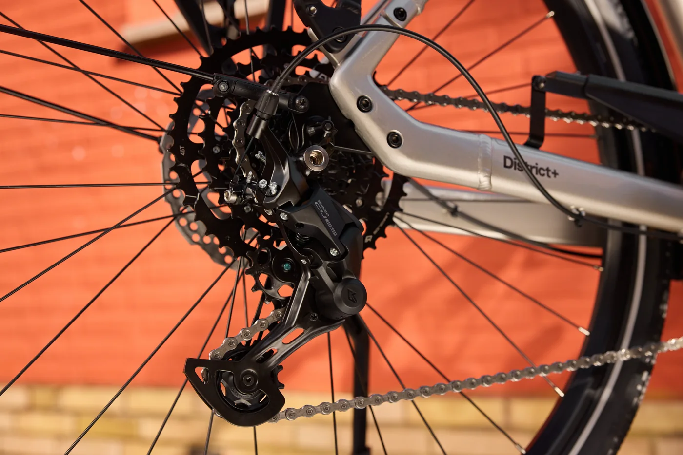 Trek District+ 3 R9 360 LS: Shimano CUES rear derailleur and cassette, grey frame.